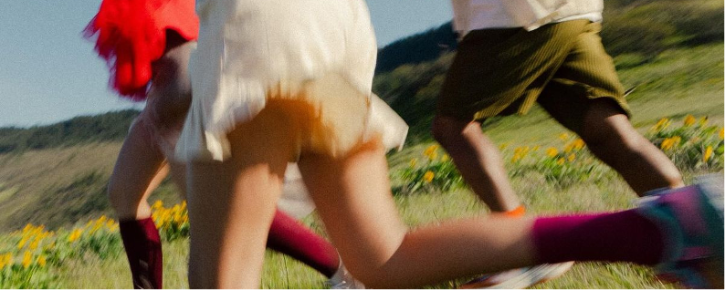 Freunde rennen durch eine sommerliche Blumenwiese